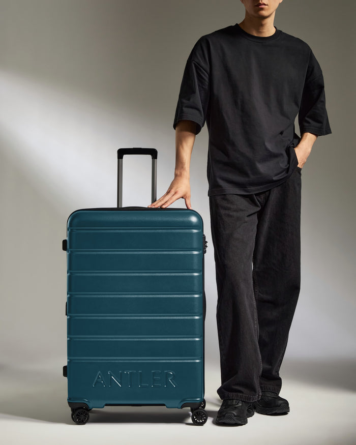 a man standing next to a suitcase