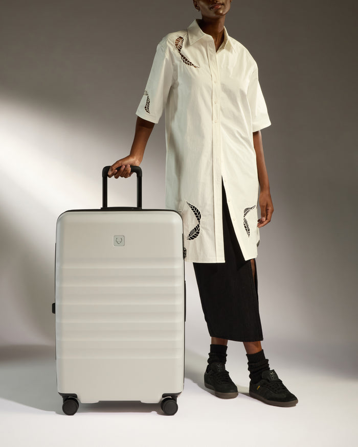 a woman standing next to a suitcase