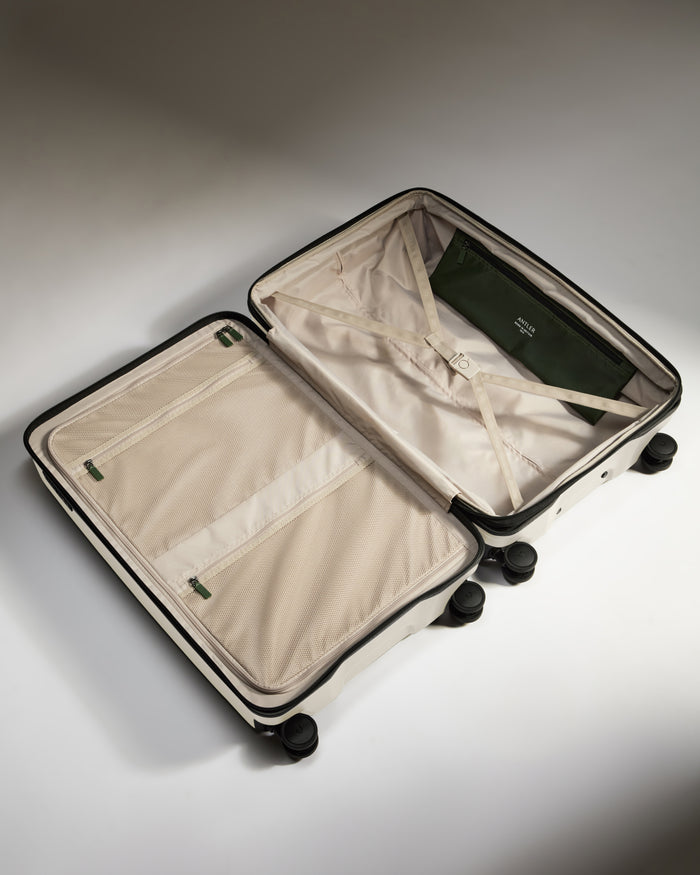 a suitcase with wheels and a green wallet
