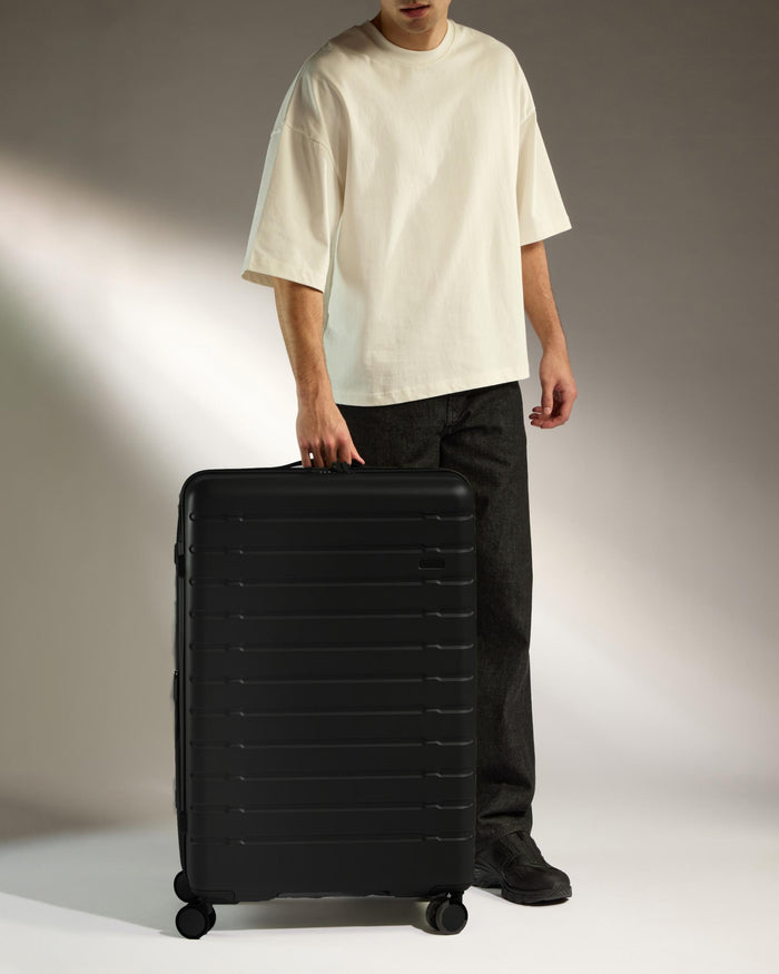 a man standing next to a suitcase
