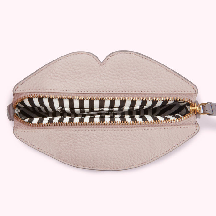 Pink lip-shaped purse open to reveal a black and white striped interior.