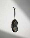 a black pouch with a gold object on it