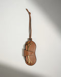 a brown leather pouch with a gold object on it