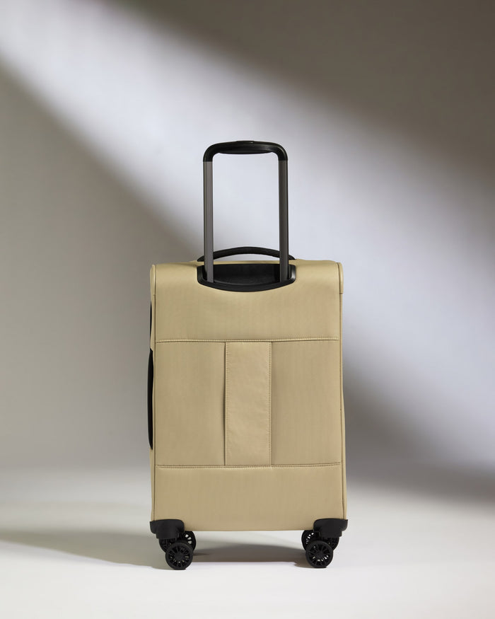 a tan suitcase with black wheels