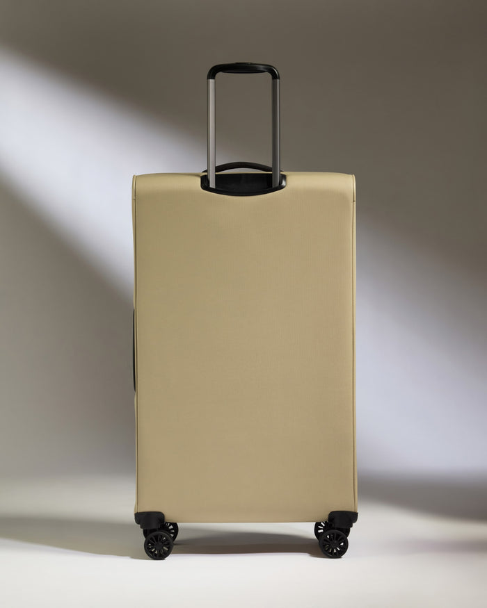 a tan suitcase with black wheels