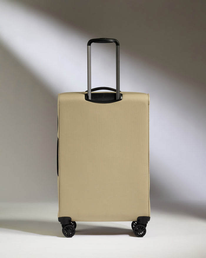 a tan suitcase with black wheels