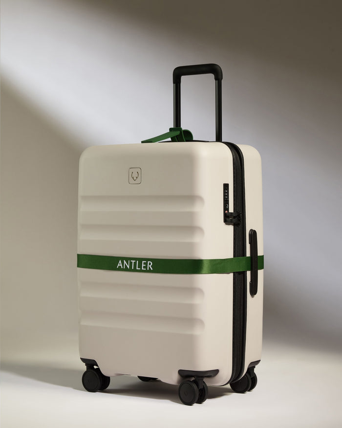a white suitcase with a green band around it