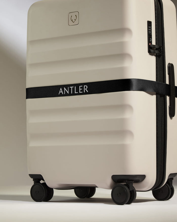 a white suitcase with black straps