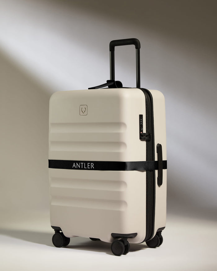 a white suitcase with black straps