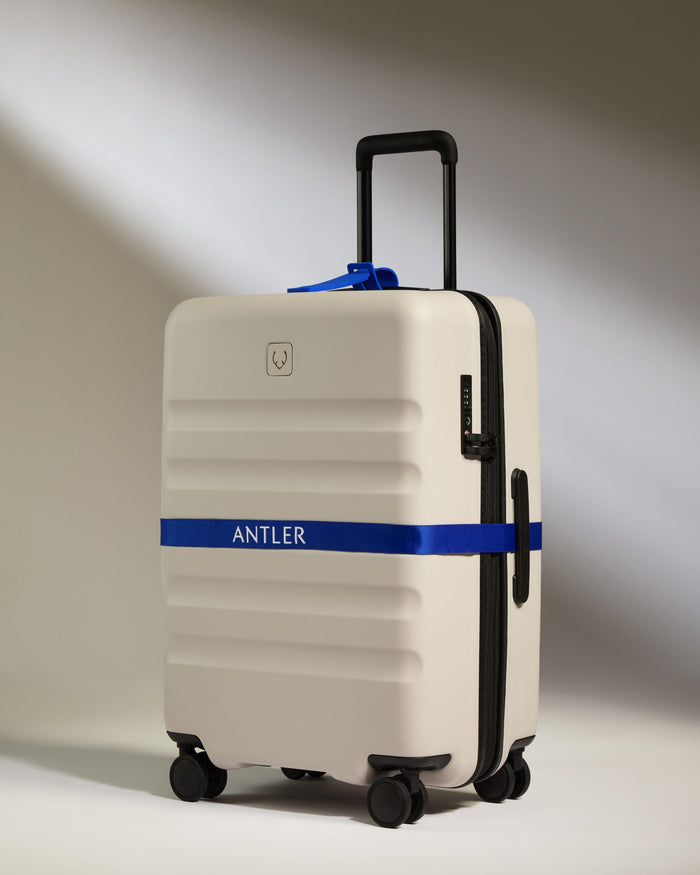 a white suitcase with a blue band around it