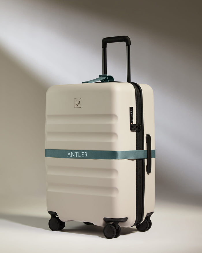 a white suitcase with a blue band around it