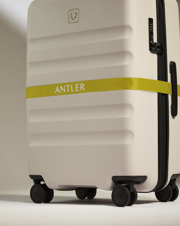 a white suitcase with a yellow band around it