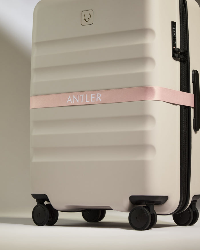 a luggage with a pink ribbon