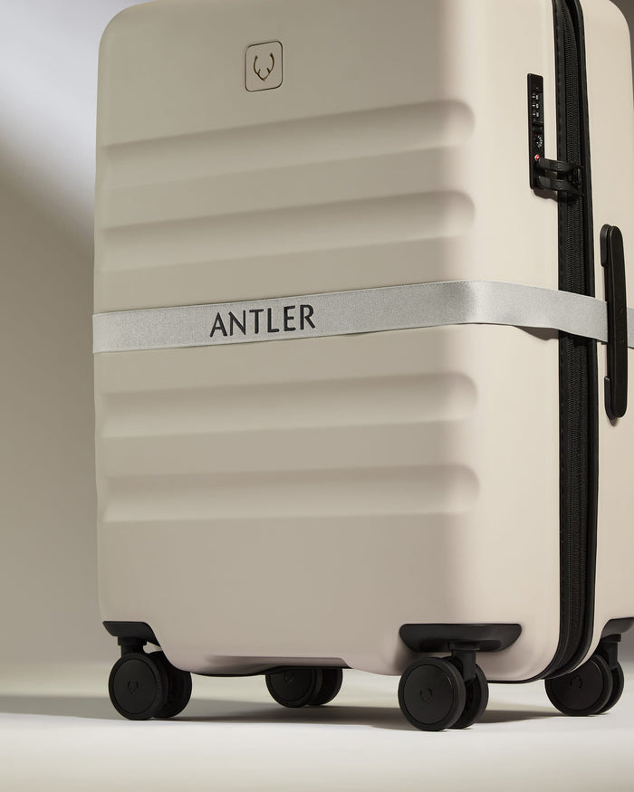 a white suitcase with a strap around it