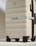 a white suitcase with a strap around it