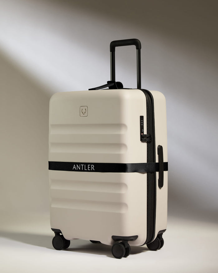 a white suitcase with black straps