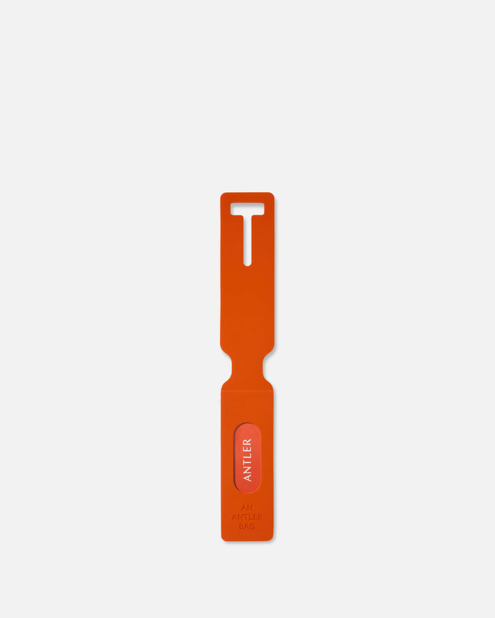 an orange plastic tool with a white label