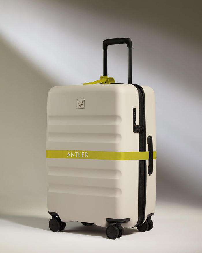 a white suitcase with a yellow band around it