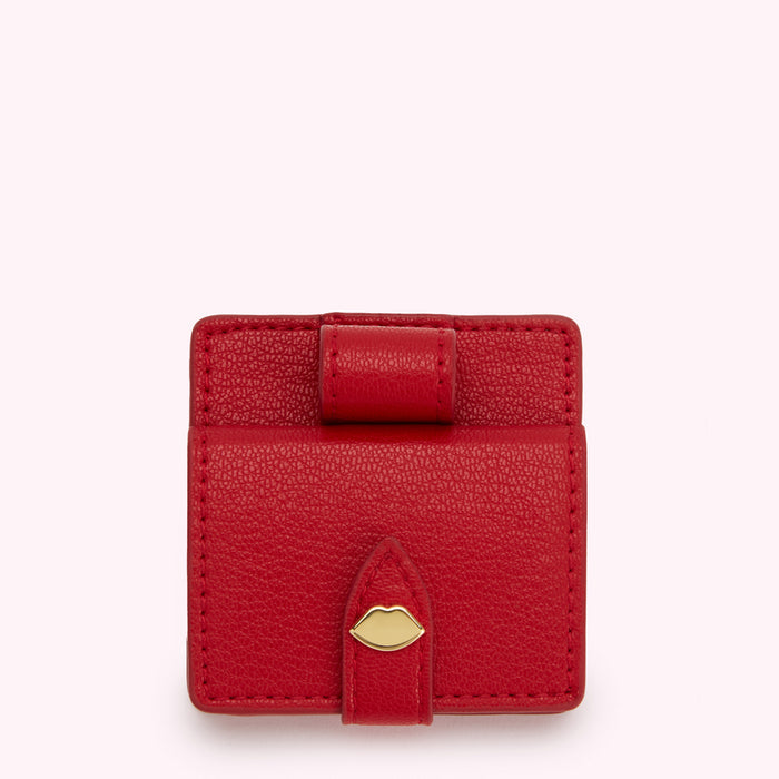 Red leather compact mirror and lipstick case with gold lip detail.