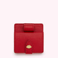 Red leather compact mirror and lipstick case with gold lip detail.