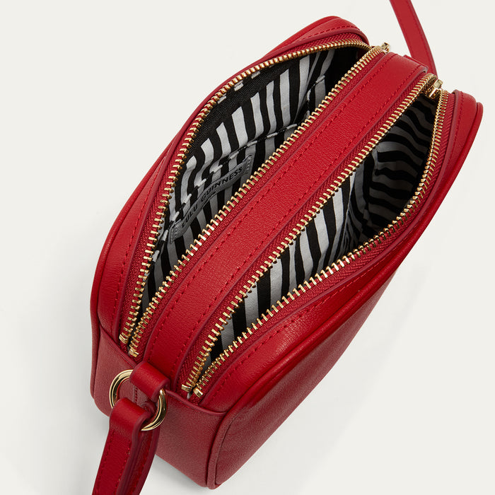 Red handbag with striped interior on a light gray background