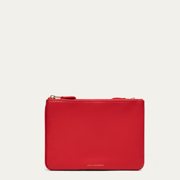 Red crossbody bag with 'Lulu Guinness' branding on a light gray background