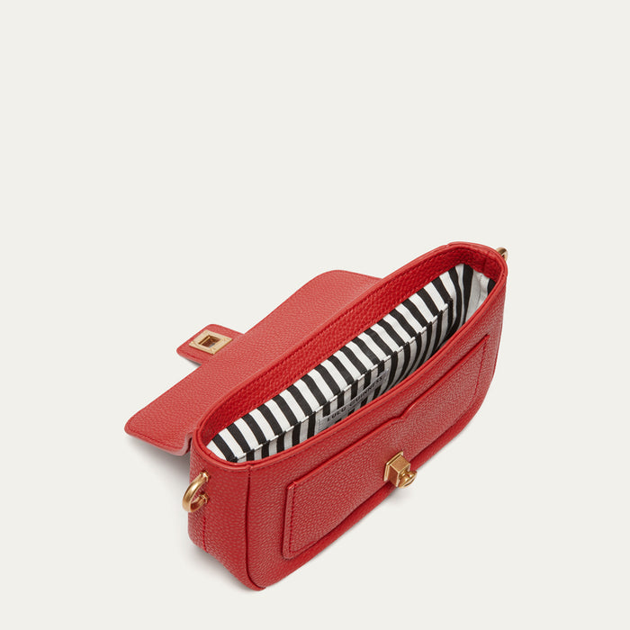 A red textured leather pouch bag with a black and white striped interior lining and gold-tone hardware, shown on a light off-white background.