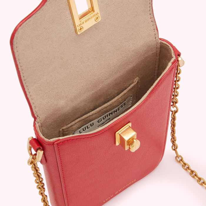 Red Lulu Guinness crossbody bag with gold chain and clasp, open to show beige interior.