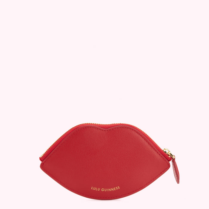 Red lip-shaped zip purse by Lulu Guinness against a white background.