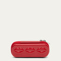 Red sunglasses case with lip details and silver zip pulls on a beige background.
