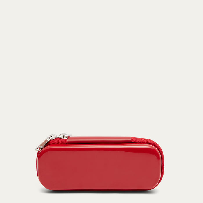 Back of a red sunglasses case with  silver zip pulls on a beige background.