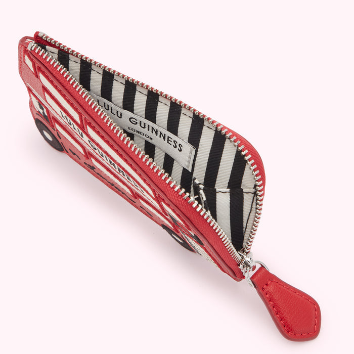 Red Lulu Guinness London bus coin purse open to reveal black and white striped interior.