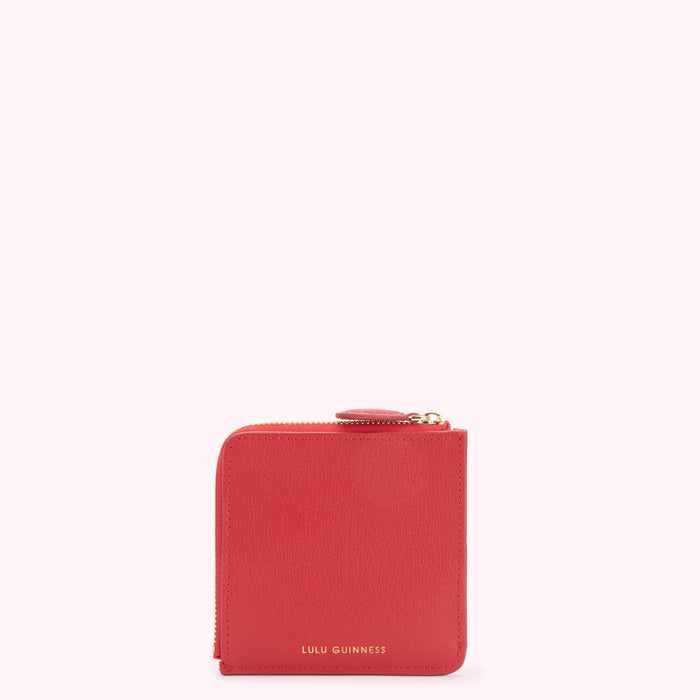 Red Lulu Guinness zip-around purse on white background.