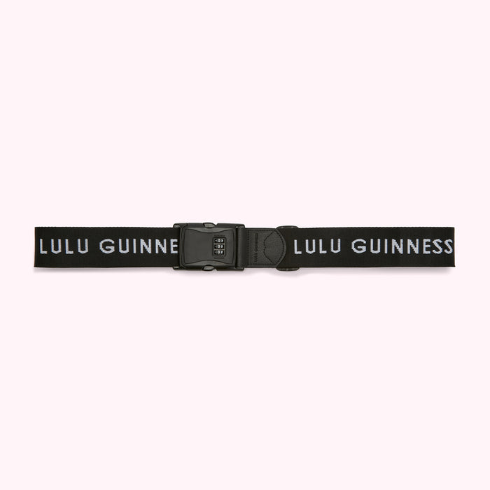 Black luggage strap with the words "Lulu Guinness" in white lettering and a combination lock.