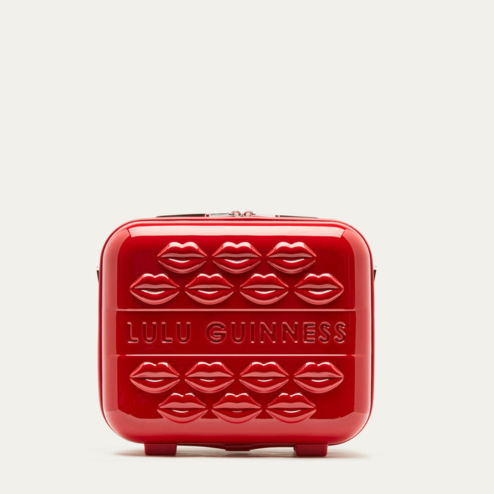 Red vanity case with lips pattern and 'Lulu Guinness' branding on a light gray background