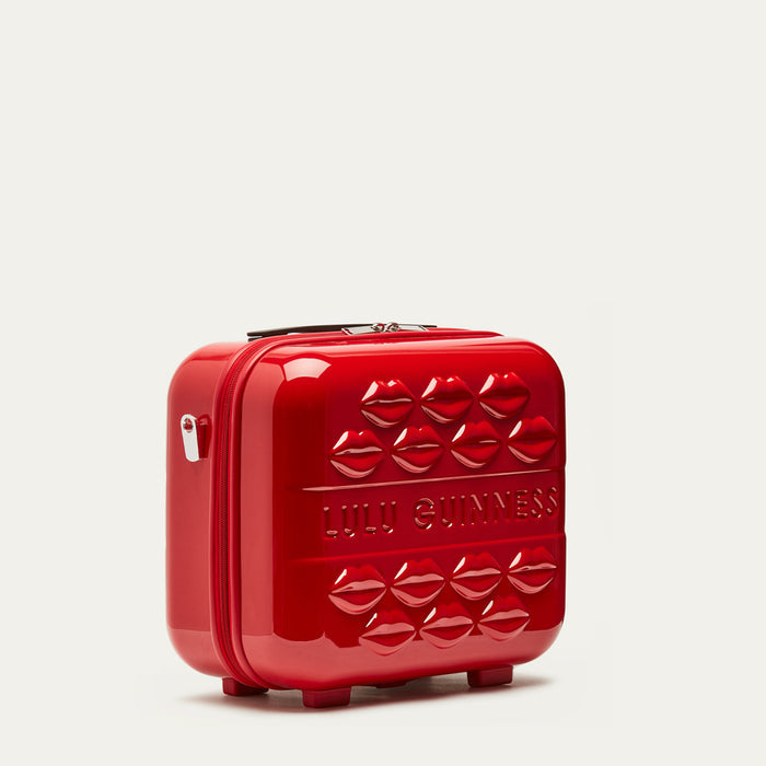 Red vanity case with embossed lip design and 'Lulu Guinness' branding on a light gray background