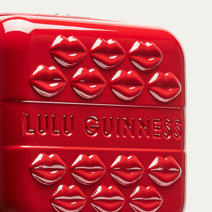 Close up image of a red vanity case with embossed lips and 'Lulu Guinness' branding