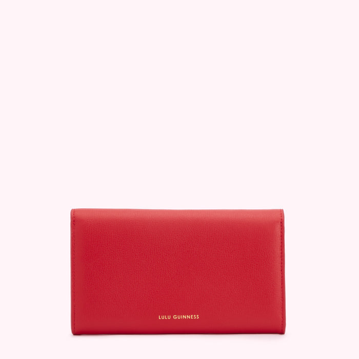 Red Lulu Guinness wallet on white background.