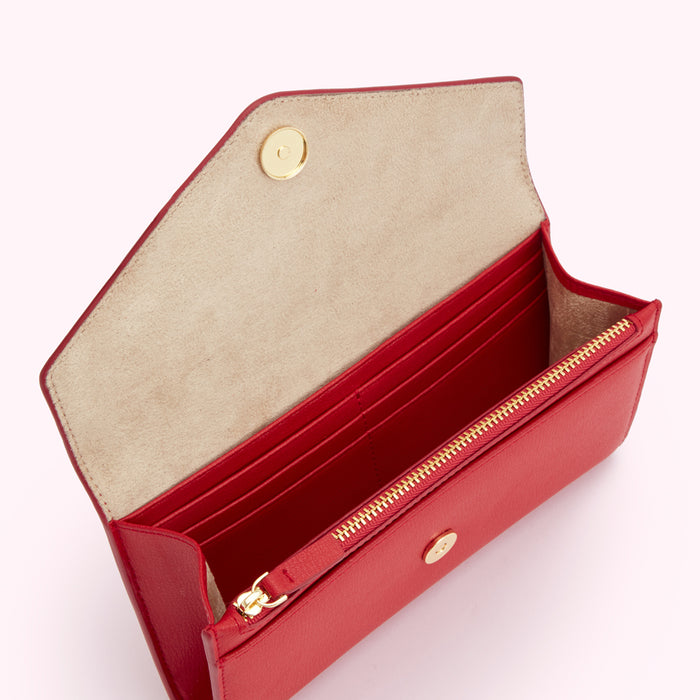 Open red leather wallet with gold zipper and fasteners. The inside is a light beige.