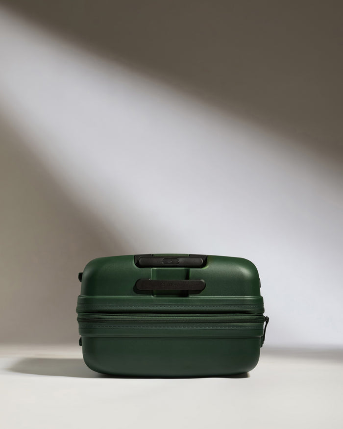 a green suitcase with a light shining on it