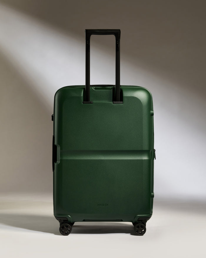 a green suitcase with black handles