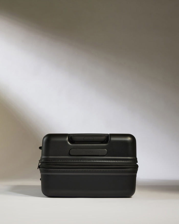 a black suitcase on a white surface