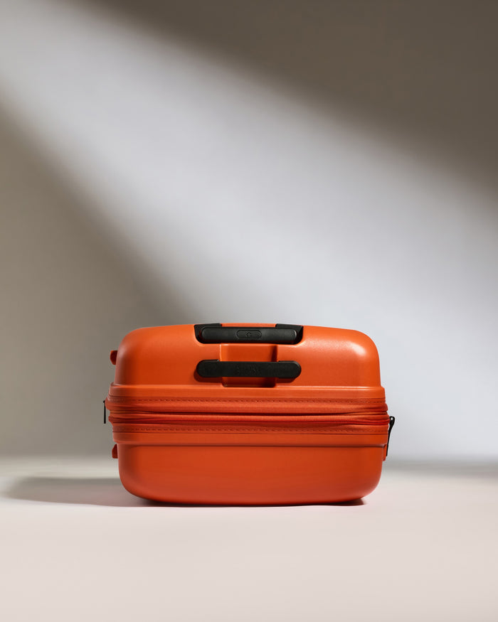 an orange suitcase with black handles