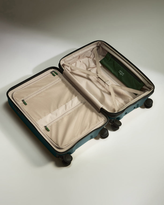 a suitcase with wheels and a green bag