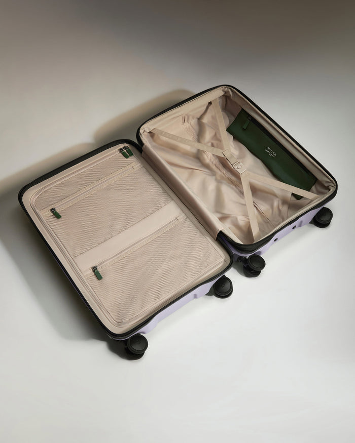 a suitcase with wheels and a green purse