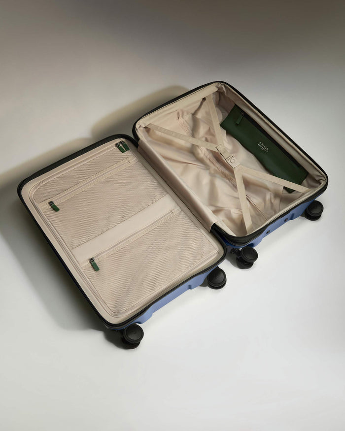 a suitcase with wheels and a green purse
