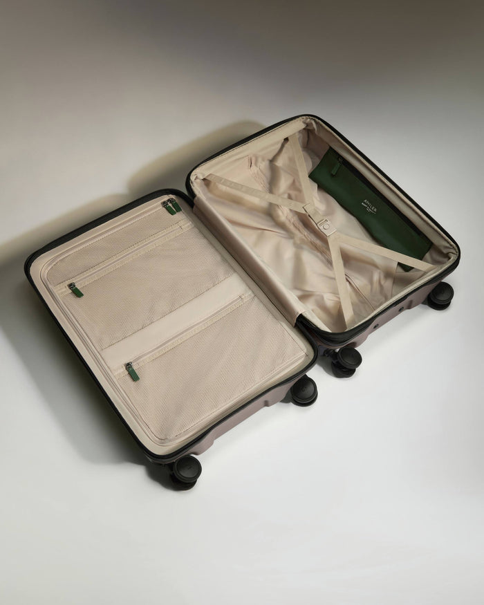 a suitcase with wheels and a green purse