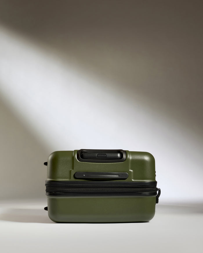 a green suitcase with a black zipper