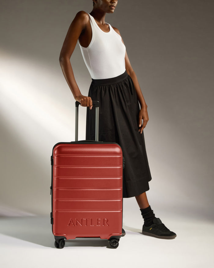 a woman standing next to a suitcase