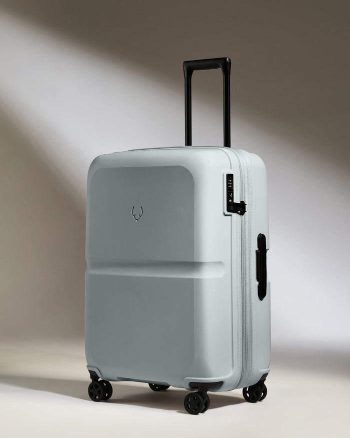 a grey suitcase with black wheels